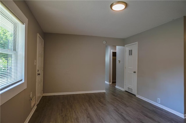 empty room with dark hardwood / wood-style flooring