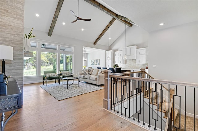 living room featuring beamed ceiling, ceiling fan, high vaulted ceiling, and light hardwood / wood-style flooring