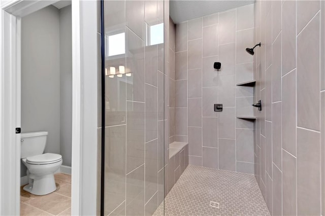 bathroom with tiled shower, tile patterned floors, and toilet