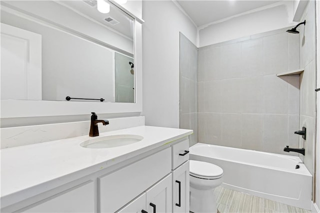 full bathroom with vanity, tiled shower / bath combo, and toilet