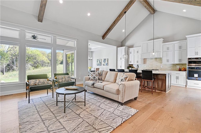 living room featuring beam ceiling, ceiling fan, high vaulted ceiling, and light hardwood / wood-style floors