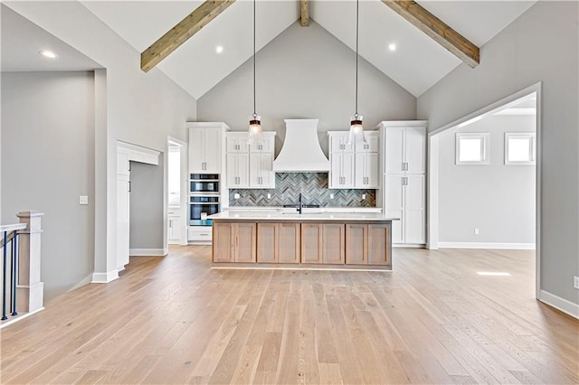 22047 W 94th St, Lenexa, KS 66220 - kitchen with premium range hood, double oven, high vaulted ceiling, light wood-type flooring, and light countertops