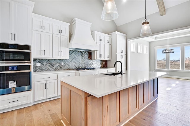 22047 W 94th St, Lenexa, KS 66220 - kitchen featuring custom exhaust hood, stainless steel double oven, light countertops, tasteful backsplash, and a kitchen island with sink