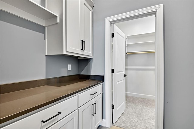 22047 W 94th St, Lenexa, KS 66220 - kitchen with dark countertops, white cabinets, and light carpet