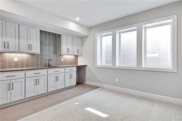 22047 W 94th St, Lenexa, KS 66220 - kitchen featuring decorative backsplash, recessed lighting, dark countertops, light colored carpet, and white cabinetry