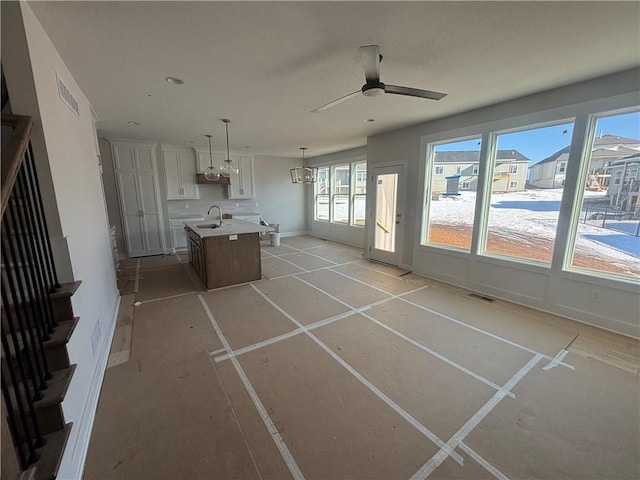 unfurnished living room with sink and ceiling fan