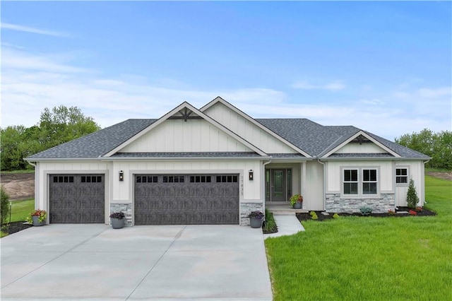 craftsman inspired home featuring a garage and a front lawn