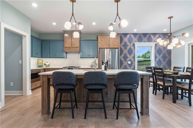 kitchen featuring light hardwood / wood-style floors, pendant lighting, and stainless steel fridge