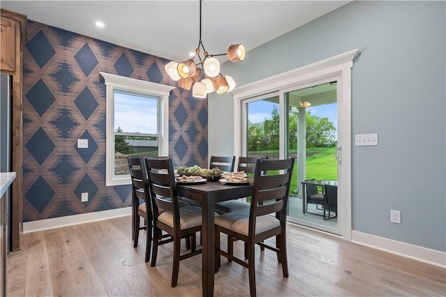 dining area featuring a wealth of natural light, a chandelier, and light hardwood / wood-style flooring