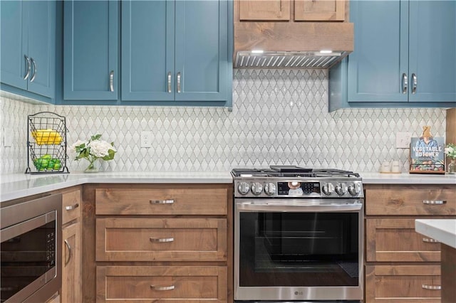 kitchen featuring tasteful backsplash, stainless steel appliances, custom range hood, and blue cabinets