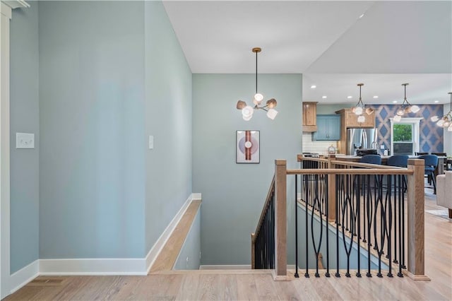 stairway featuring a chandelier and hardwood / wood-style flooring