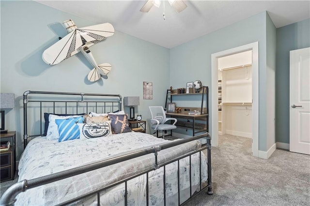 bedroom featuring a walk in closet, carpet floors, and ceiling fan