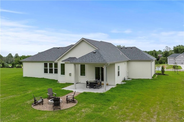 rear view of property featuring an outdoor fire pit, a yard, and a patio