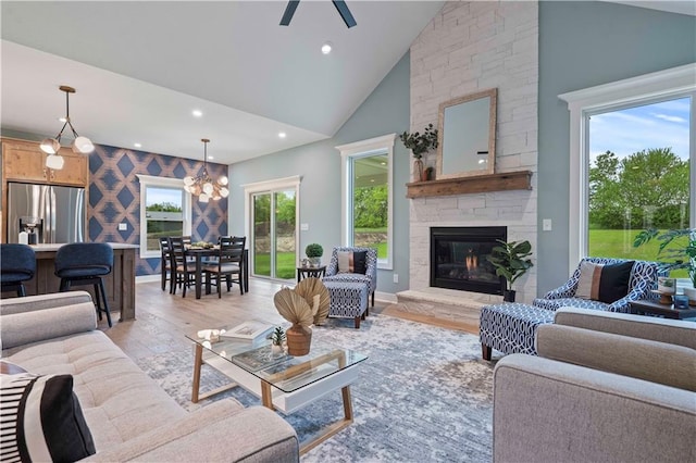 living room featuring light hardwood / wood-style flooring, a fireplace, high vaulted ceiling, and plenty of natural light