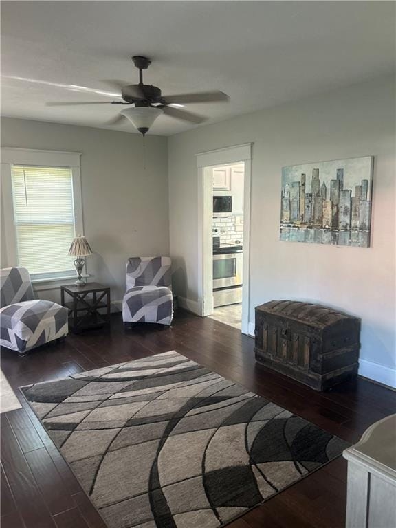 living room featuring ceiling fan and dark hardwood / wood-style flooring