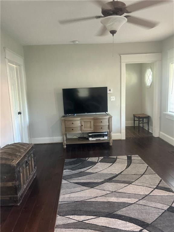 living room with dark wood-type flooring and ceiling fan