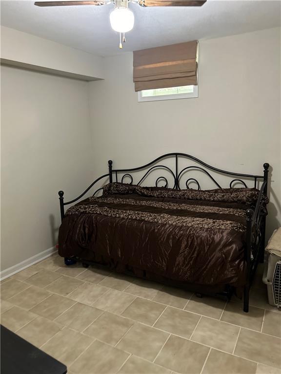 tiled bedroom with ceiling fan