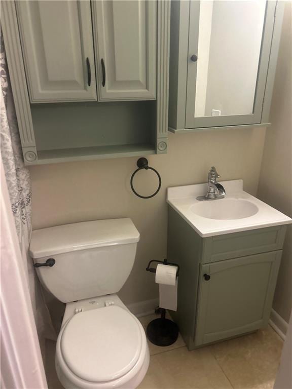 bathroom with tile patterned flooring, vanity, and toilet