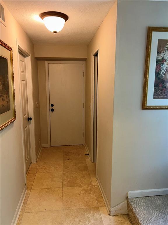 hallway with a textured ceiling