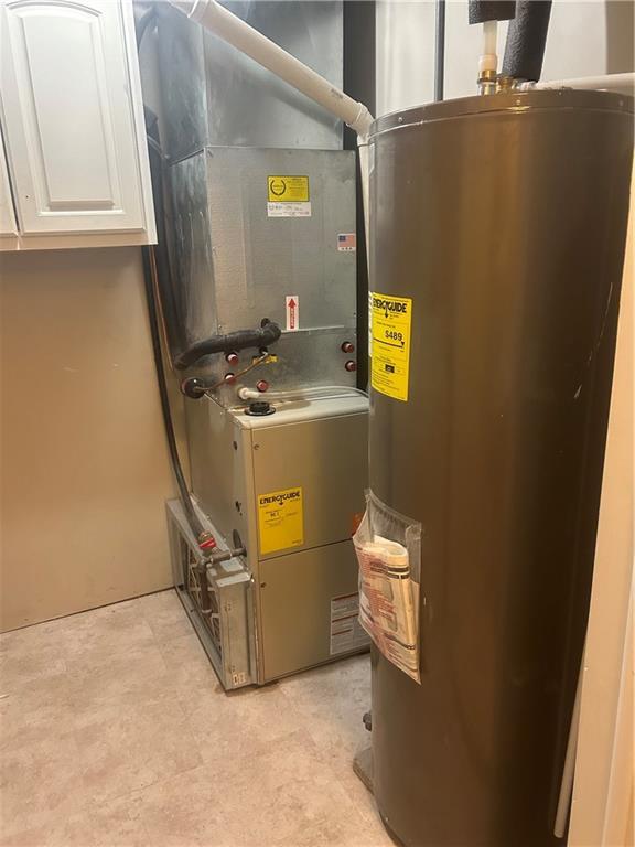 utility room featuring heating unit and water heater