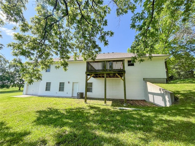 back of property with central AC and a lawn