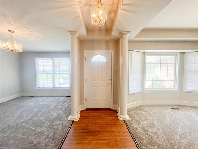 foyer featuring carpet floors, a wealth of natural light, and a chandelier