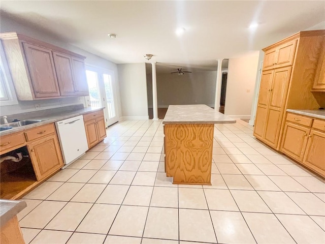 kitchen featuring ceiling fan, dishwasher, a kitchen island, light tile floors, and sink