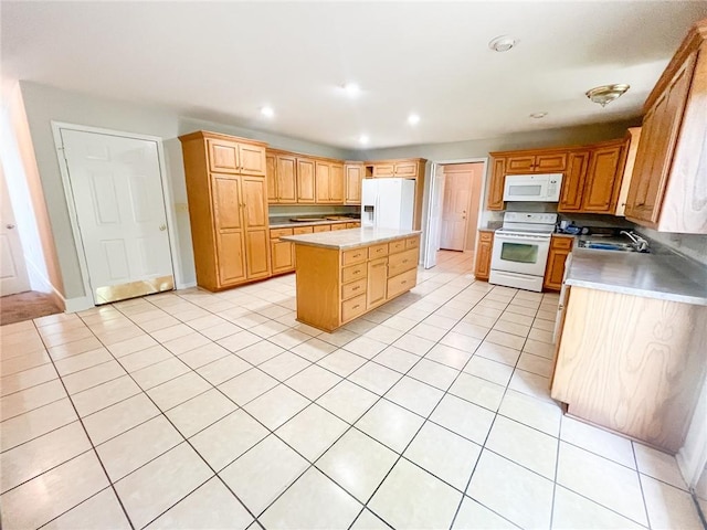 kitchen featuring sink, white appliances, light tile flooring, and a kitchen island