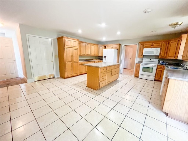 kitchen with sink, a center island, white appliances, and light tile floors