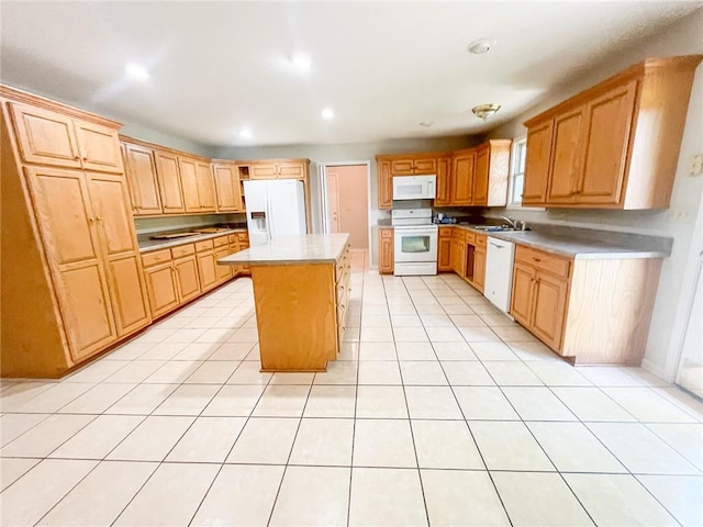 kitchen with white appliances, a breakfast bar area, a kitchen island, and light tile floors