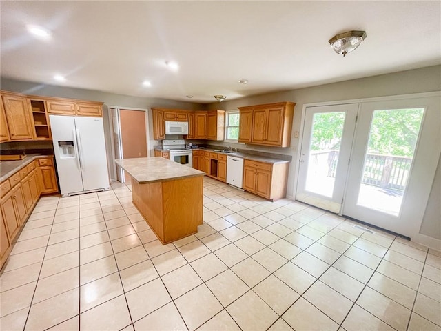 kitchen featuring a kitchen island, white appliances, and light tile floors