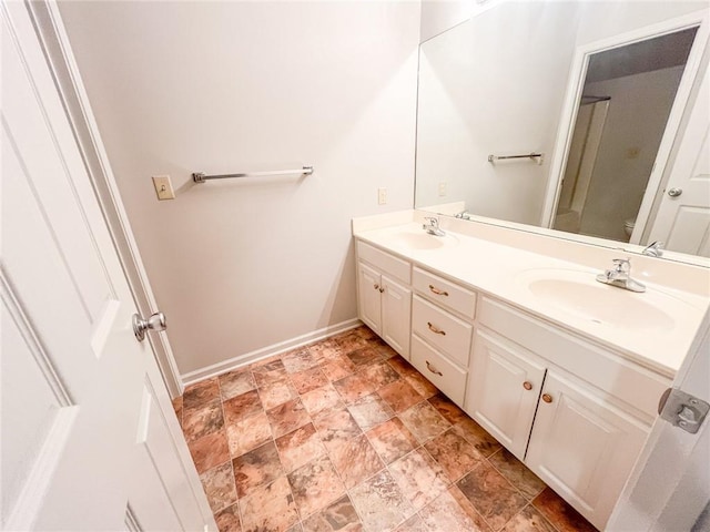 bathroom with tile floors, large vanity, toilet, and double sink