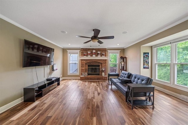 living room featuring plenty of natural light, wood-type flooring, and a brick fireplace