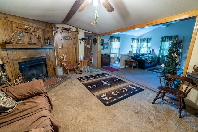 living room featuring vaulted ceiling with beams, carpet flooring, wooden walls, and ceiling fan