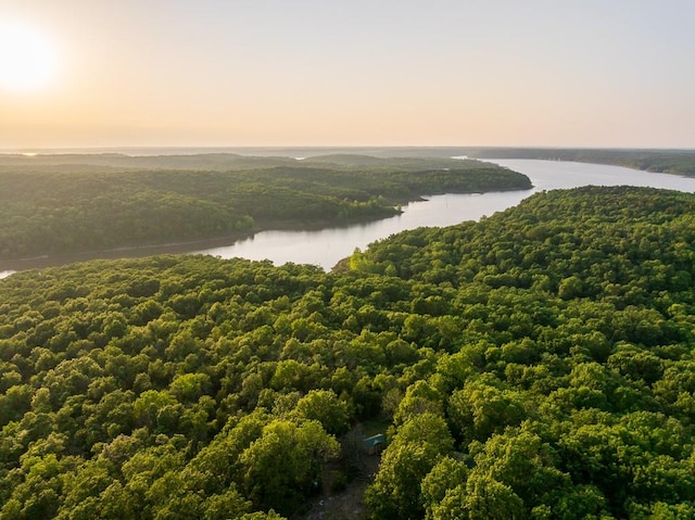 aerial view at dusk featuring a water view