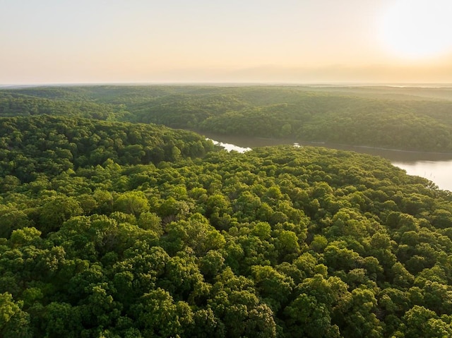 aerial view at dusk featuring a water view