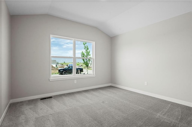 empty room featuring carpet floors and vaulted ceiling