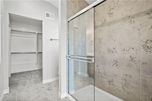 bathroom with a shower with shower door and vaulted ceiling