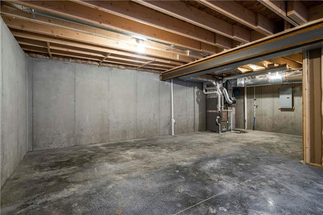 basement featuring electric panel and heating unit