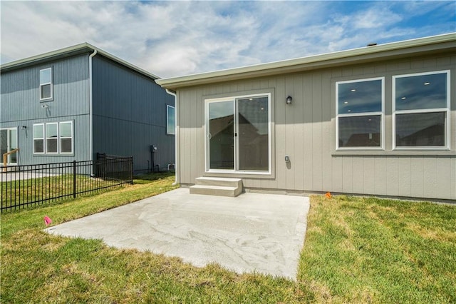 back of house featuring a lawn and a patio area