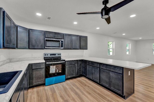 kitchen featuring ceiling fan, stainless steel appliances, light hardwood / wood-style floors, and kitchen peninsula