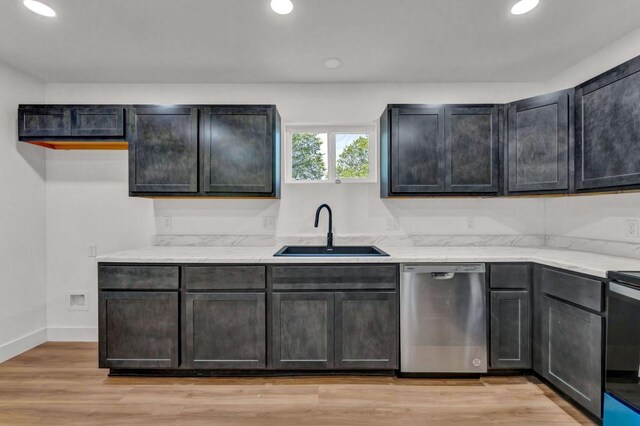 kitchen featuring light wood-type flooring, light stone counters, electric stove, sink, and dishwasher