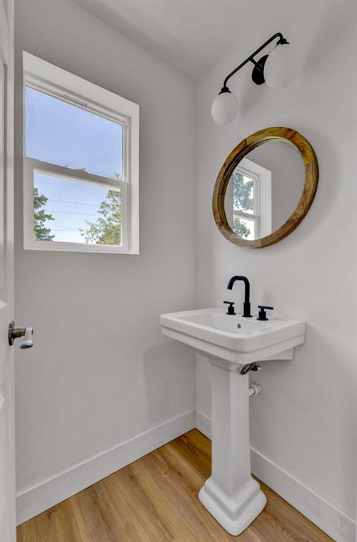 bathroom with a wealth of natural light, wood-type flooring, and sink