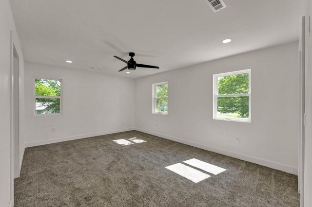 unfurnished room featuring dark carpet and ceiling fan