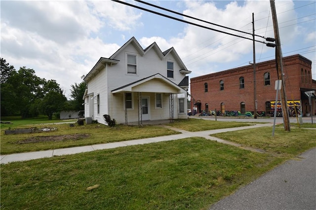 view of front of property featuring covered porch, central AC unit, and a front lawn