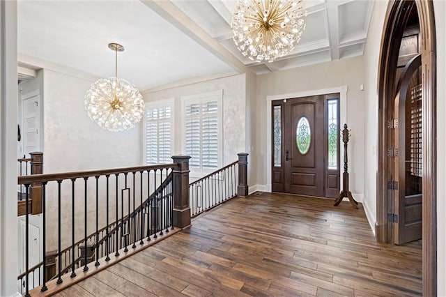 foyer entrance featuring beam ceiling, coffered ceiling, dark hardwood / wood-style floors, and a notable chandelier