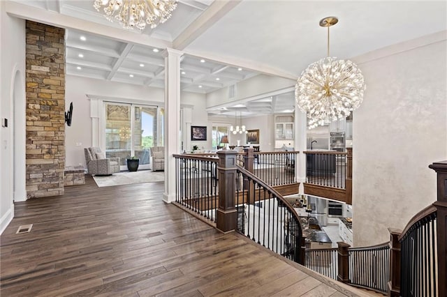 hall with coffered ceiling, hardwood / wood-style flooring, ornate columns, beam ceiling, and a chandelier