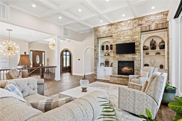 living room featuring coffered ceiling, built in shelves, wood-type flooring, beam ceiling, and a fireplace