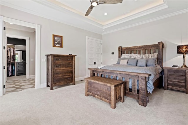 bedroom with light carpet, a raised ceiling, ceiling fan, and ornamental molding