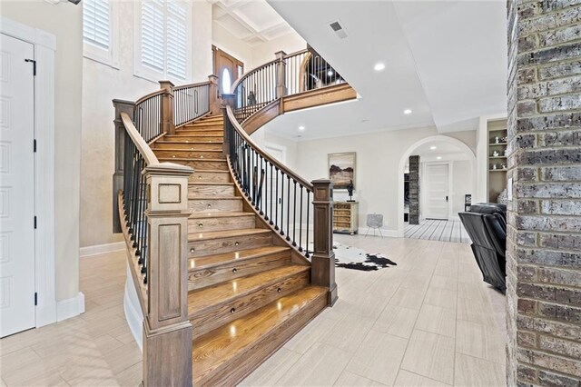 stairs featuring a high ceiling and built in shelves